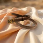 Brown Valentino Garavani VLogo thin leather belt with antique brass buckle on a stone pedestal (3)