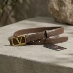 Brown Valentino Garavani VLogo thin leather belt with antique brass buckle on a stone pedestal (4)