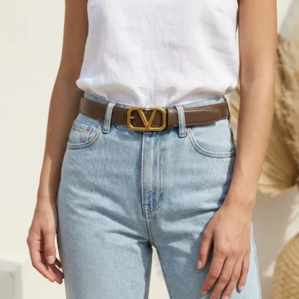 Brown Valentino Garavani VLogo thin leather belt with antique brass buckle on a stone pedestal (6)