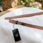 Slim black leather womens belt with a polished silver tone interlocking buckle (1)