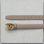Slim womens taupe leather belt featuring an antique gold interlocking buckle on a stone pedestal (3)