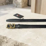 Women wearing a black leather belt with a gold V logo buckle (1)
