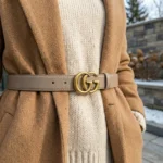 Womens Gucci Double G leather belt in taupe with antique brass hardware on a stone pedestal (3)