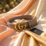 Womens Gucci Double G leather belt in taupe with antique brass hardware on a stone pedestal (4)